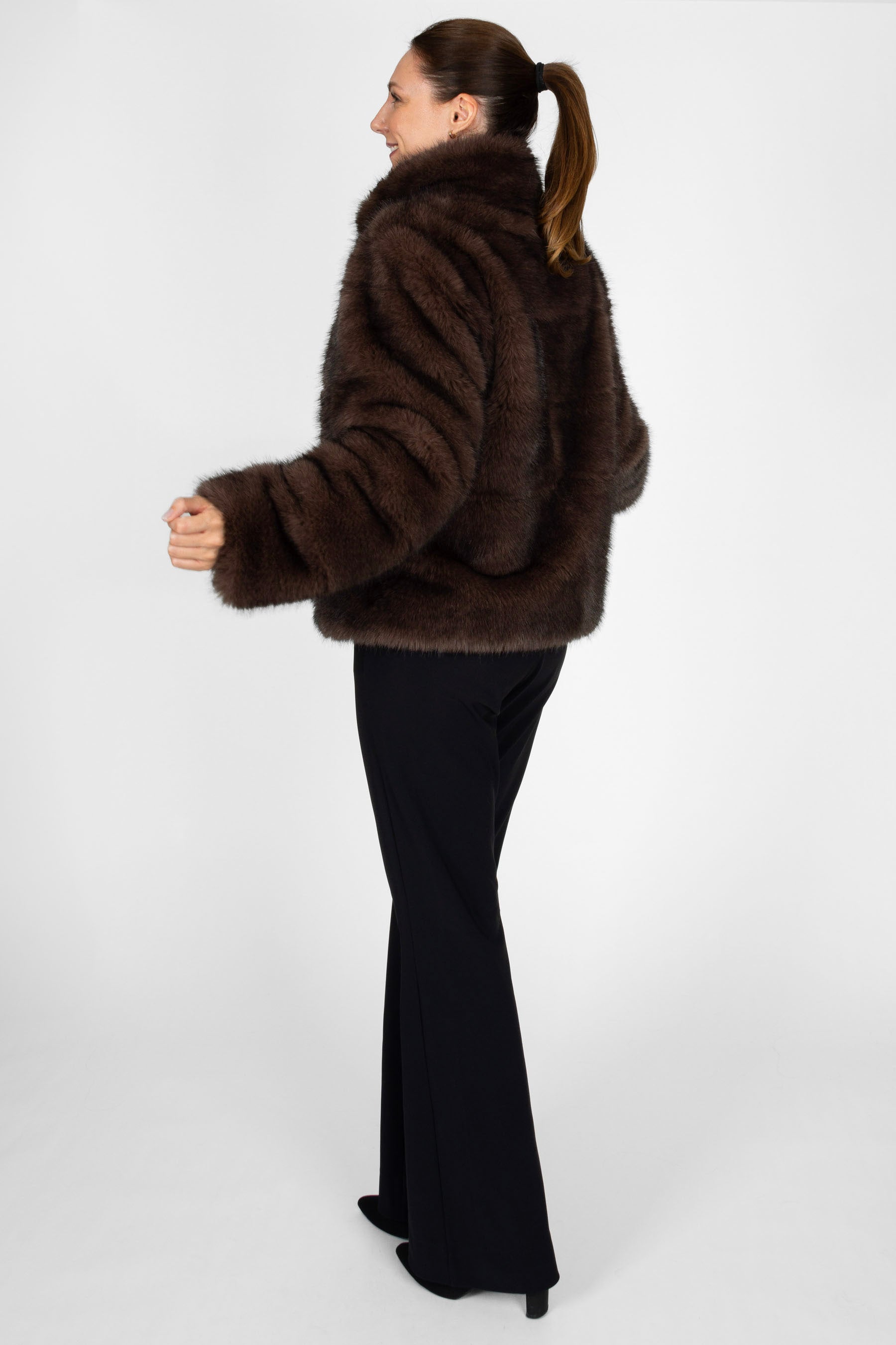 Seitenansicht der kurzen Damenjacke in Dunkelbraun mit Two-Tone Pelzoptik und Stehbordkragen