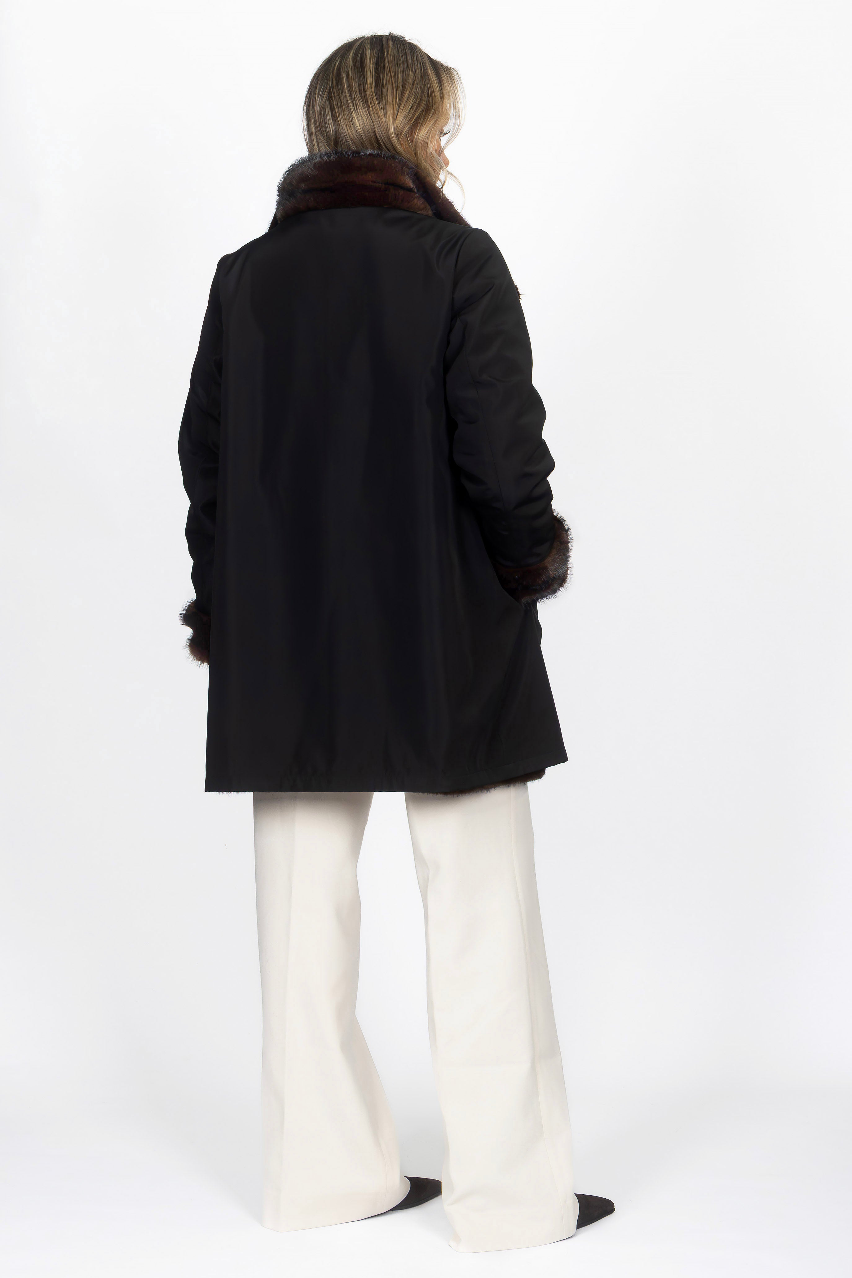 Model trägt den Wendemantel in Black/Darkbrown von hinten